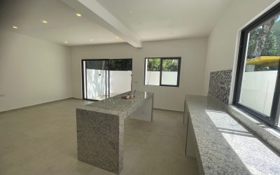 #40 Puerto Morelos - Aldea Umm kitchen countertop and island with ambient light from nearby window and sliding glass doors to the patio